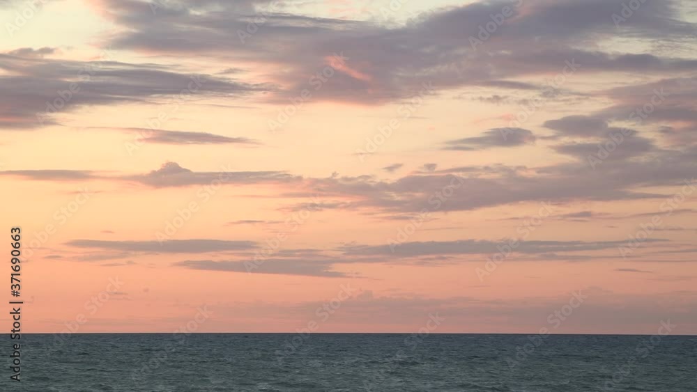 Scenic. Orange pink yellow skyline wispy clouds at dusk with waves rolling. Wide static. Real-time. Lake Huron Scenic. Orange pink yellow skyline wispy clouds at dusk with waves rolling. Wide static. Real-time. Lake Huron