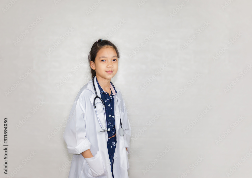 Dream careers concept, Portrait of Happy kid in doctor coat with stethoscope on blurred background Dream careers concept, Portrait of Happy kid in doctor coat with stethoscope on blurred background
