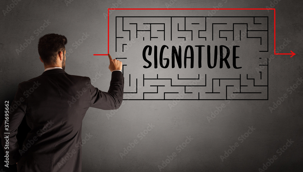 businessman drawing maze with SIGNATURE inscription, business education concept businessman drawing maze with SIGNATURE inscription, business education concept