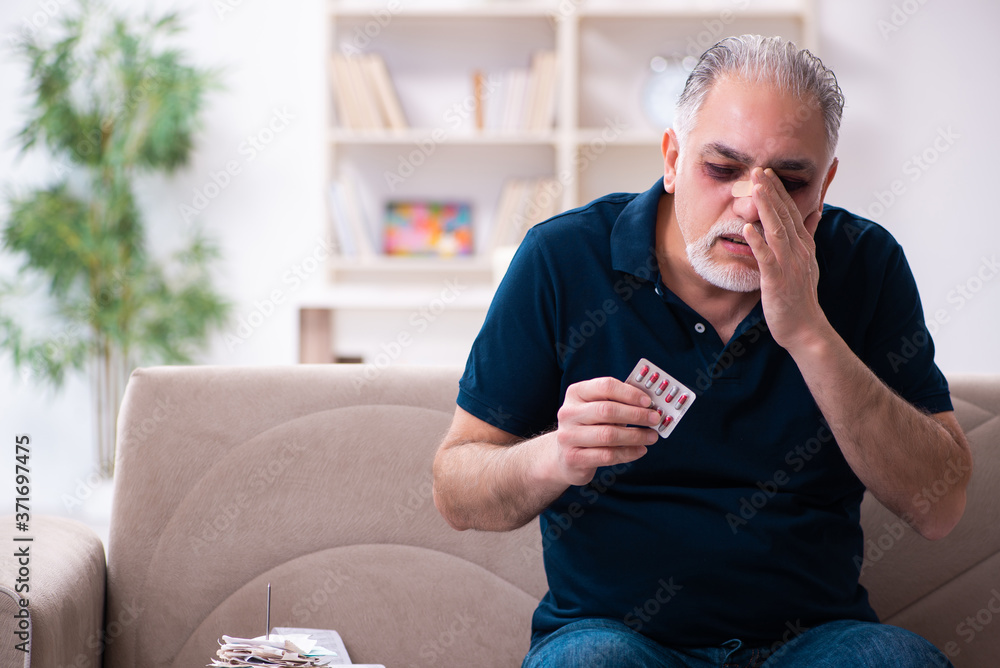 Old injured man in budget planning concept Old injured man in budget planning concept