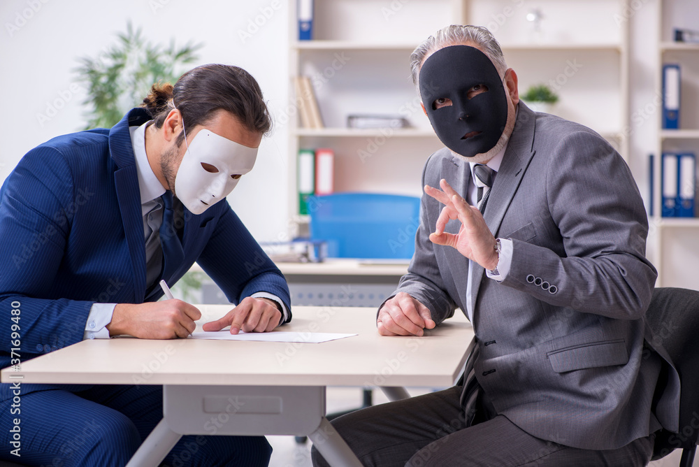 Two businessmen wearing masks during negotiations Two businessmen wearing masks during negotiations