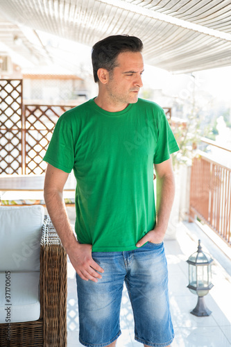 Middle Aged Man With Green T-Shirt Standing Outdoors