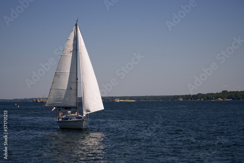 A sail boat on a river on a sunny, summers day © Joe