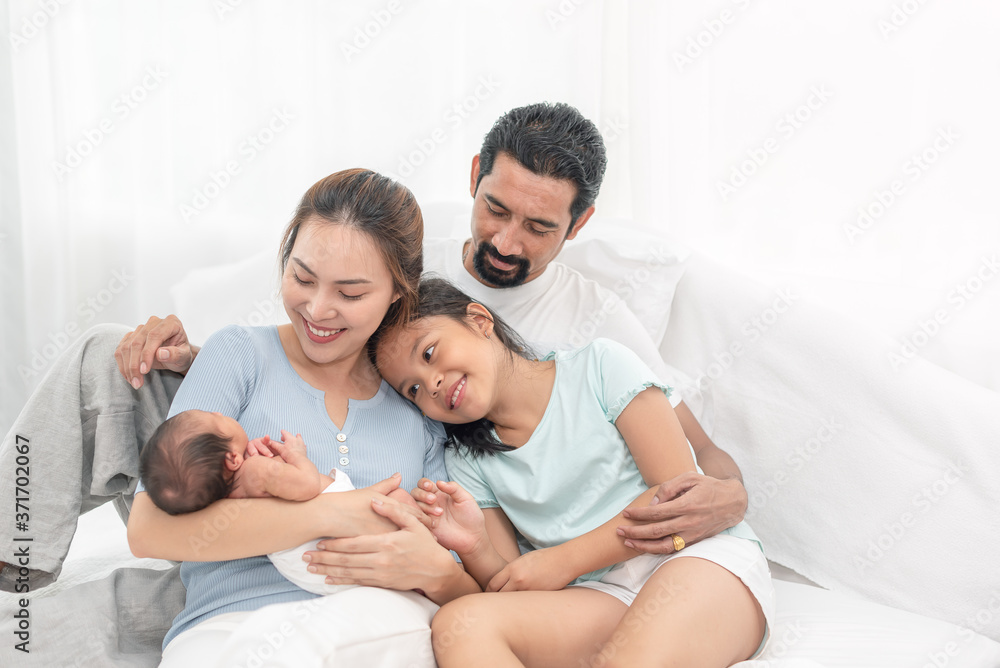 Parent and children relaxing together. Portrait of a young family with mother, father, son and daugther. Parents having happy time, welcoming newborn. Parent and children relaxing together. Portrait of a young family with mother, father, son and daugther. Parents having happy time, welcoming newborn.
