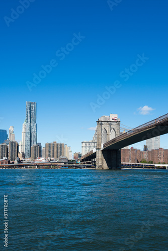 Brooklyn Bridge and Manhattan skyline in New York with blue sky © Mark