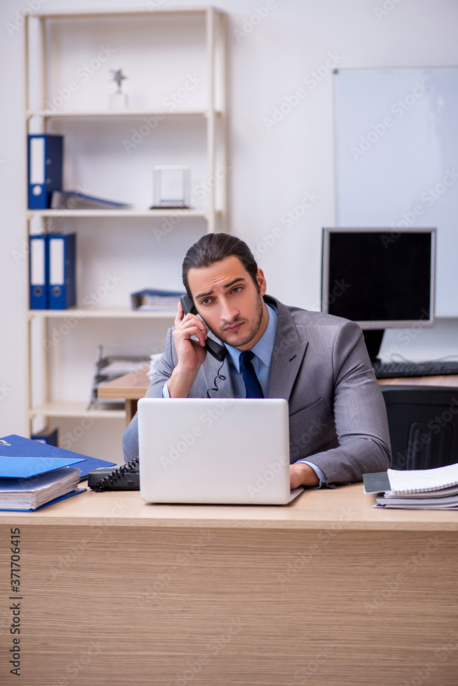Young male businessman employee working in the office Young male businessman employee working in the office