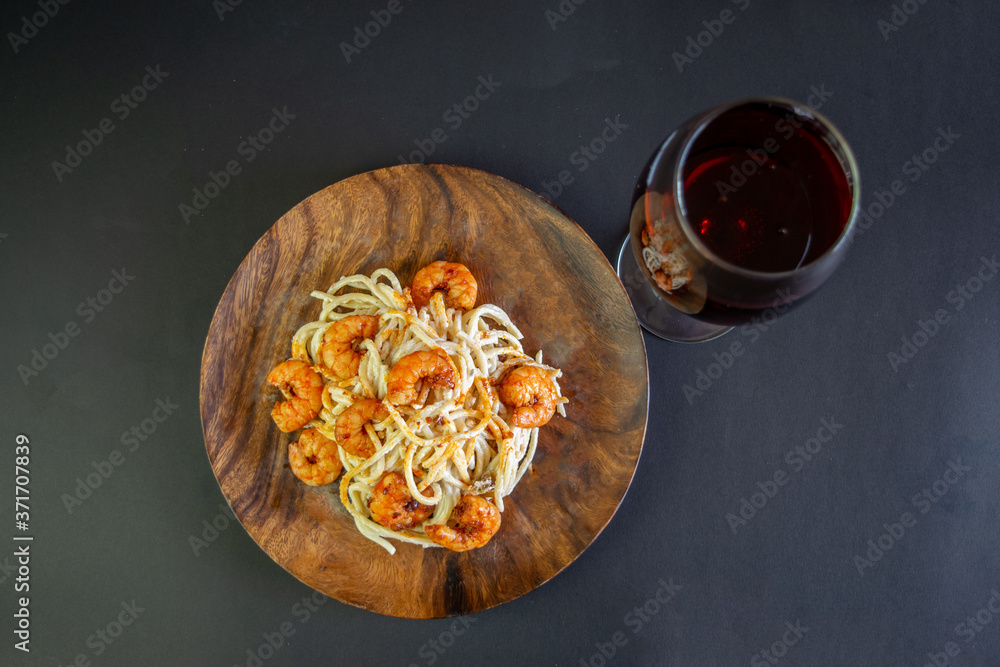 pasta with shrimp and red wine on black background pasta with shrimp and red wine on black background