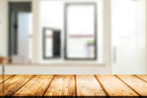 Wooden desk space and blurry background of home window for product display montage. © qOppi