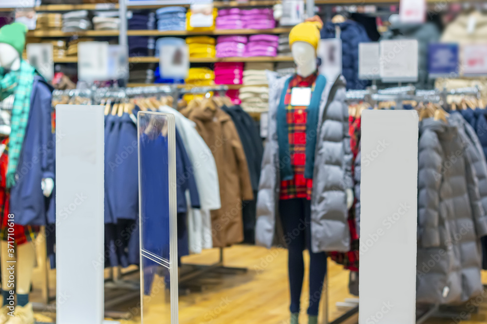 Blurred showcases boutique with autumn and winter clothes. Black Friday, season Christmas sale and shopping concept. Blurred bokeh mock up for design in shopping department store. Out focus