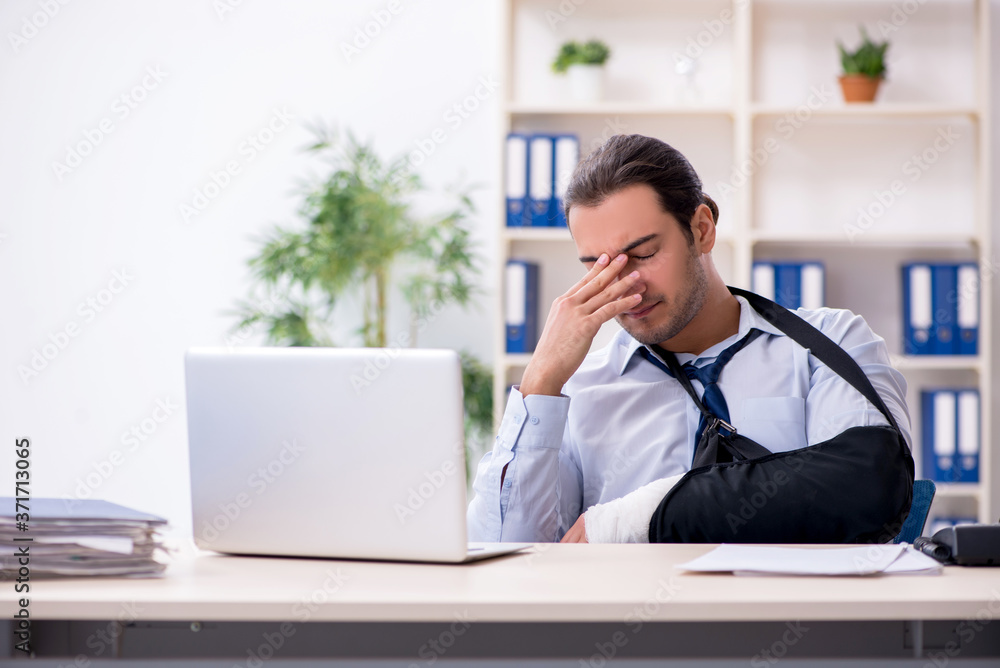 Injured male employee at workplace after accident Injured male employee at workplace after accident