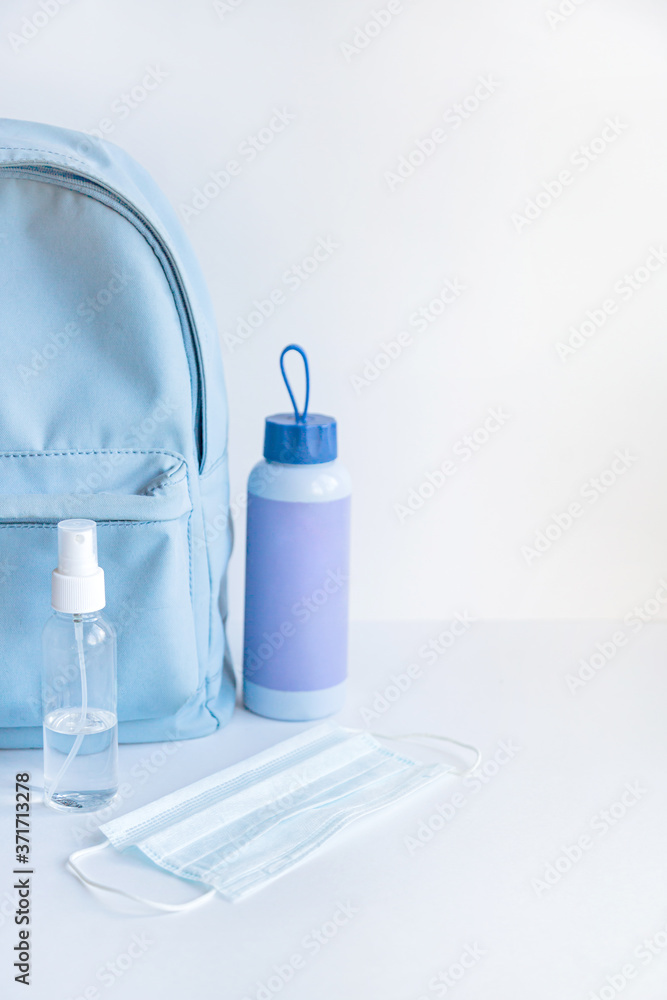 Backpack, water bottle, face mask and antiseptic on a white background. Walking concept. Backpack, water bottle, face mask and antiseptic on a white background. Walking concept.