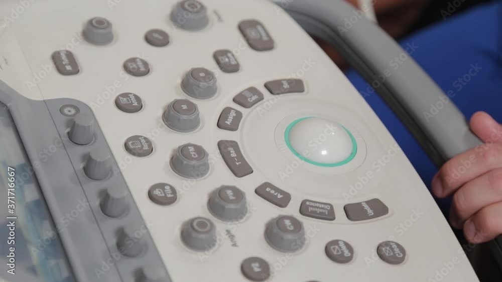Doctor setting up an ultrasound machine at a medical center. Doctor setting up an ultrasound machine at a medical center.
