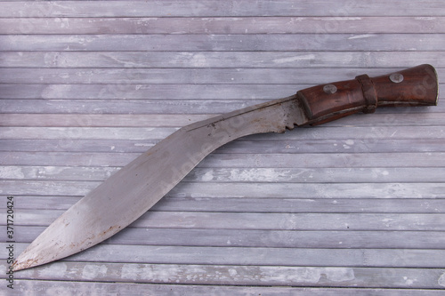 Vintage Ghurkha Khukri Knife slightly rusty on grey wooden background photo