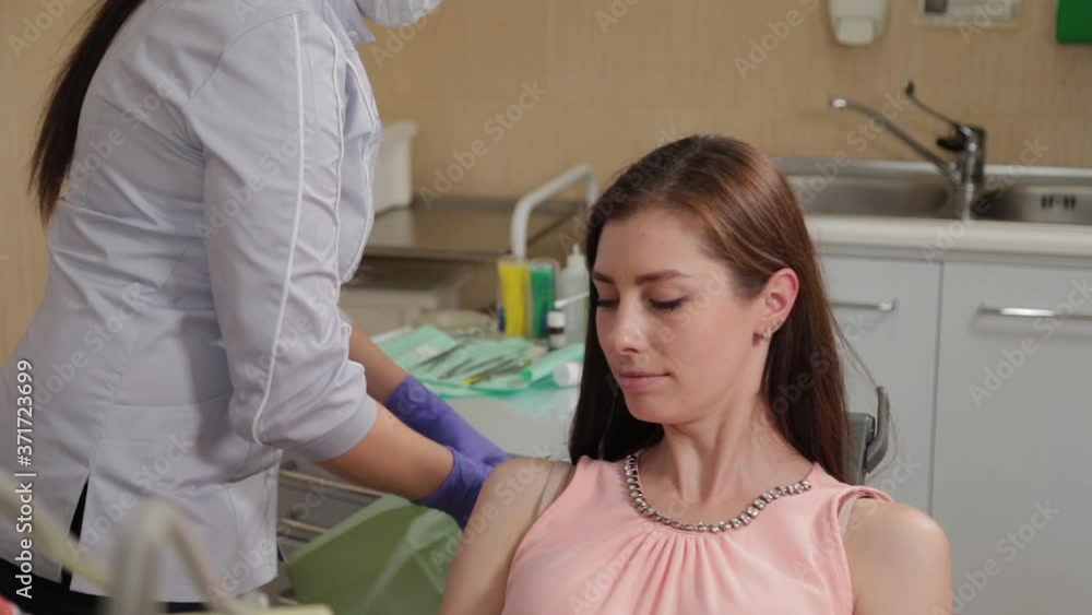 Woman dentist talking to patient. Woman dentist talking to patient.