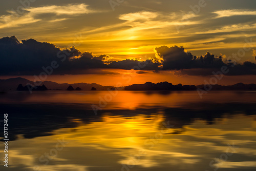 Sunset sky with cloud and silhouette mountain at the lake.