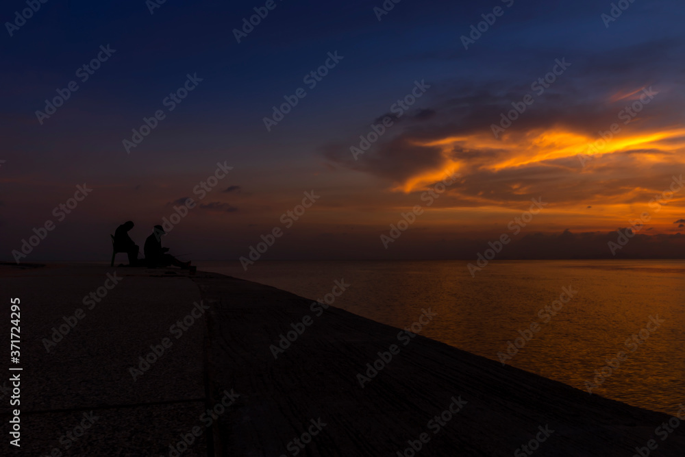 silhouette of fishermen at the lake with twilight sky. silhouette of fishermen at the lake with twilight sky.