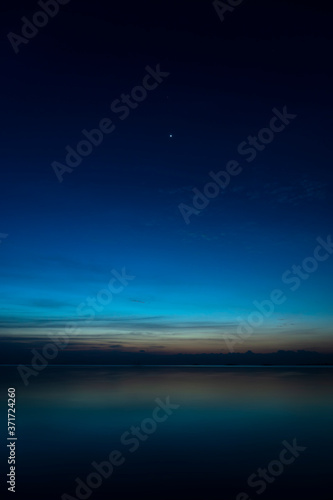 The sky with star at the lake in the twilight after sunset. © noppharat
