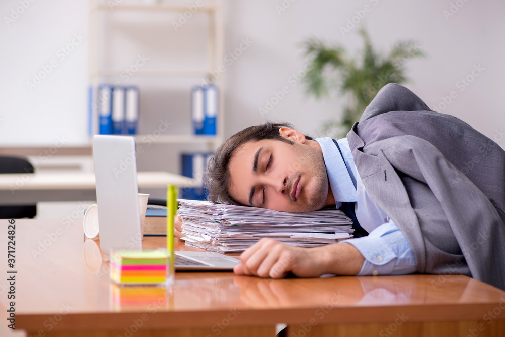 Young male employee sleeping in the office Young male employee sleeping in the office