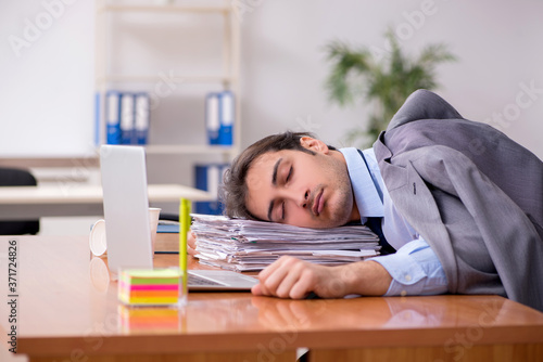 Young male employee sleeping in the office