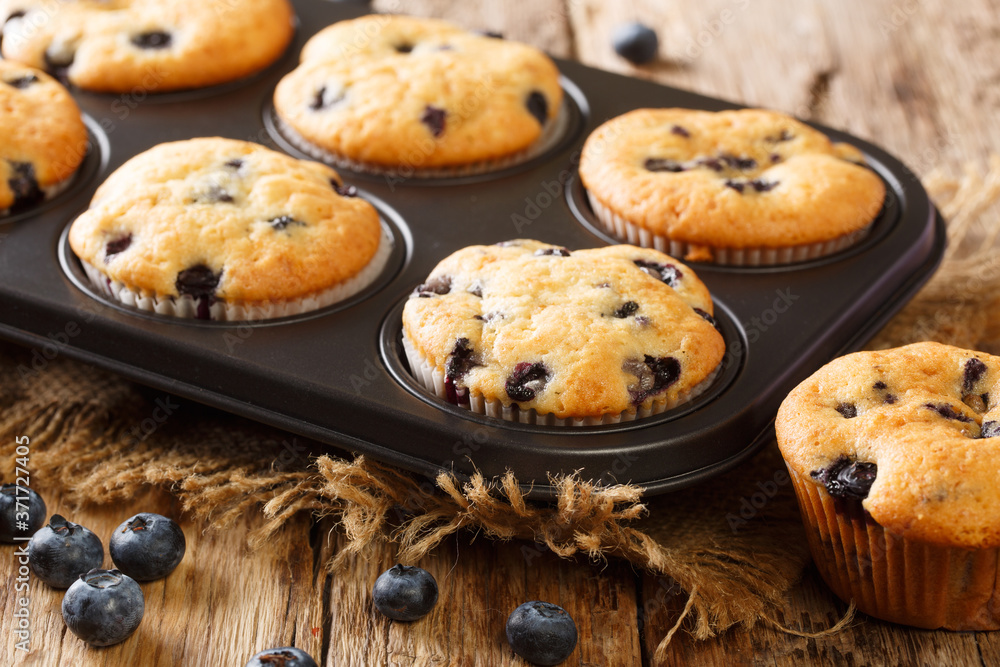 Only from the oven muffins with blueberries close-up in a baking dish on the table. horizontal Only from the oven muffins with blueberries close-up in a baking dish on the table. horizontal