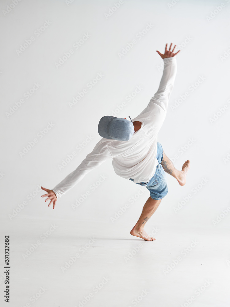 Cool young guy breakdancer jumps dancing hip-hop isolated on white background. Dance school poster. Back view