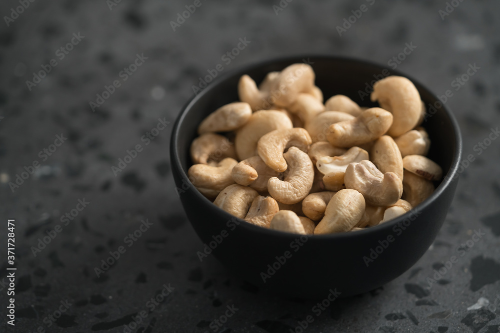 roasted cashew in black bowl on terrazzo countertop roasted cashew in black bowl on terrazzo countertop