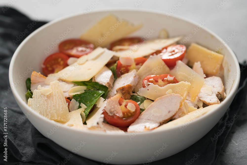 Fresh caesar salad with chicken and cherry tomatoes in white bowl Fresh caesar salad with chicken and cherry tomatoes in white bowl