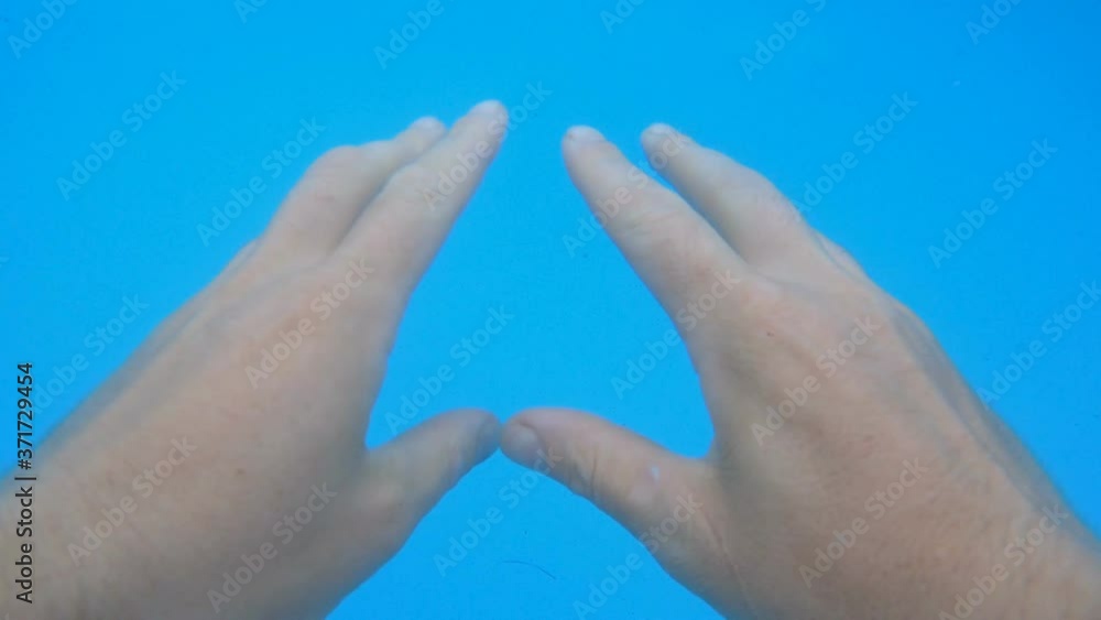Underwater recording - Showing bare hands in murky swimming pool water with blue liner. Underwater recording - Showing bare hands in murky swimming pool water with blue liner.