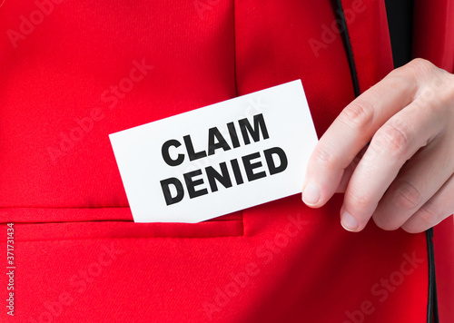 Businessman putting a card with text Claim Denied in the pocket