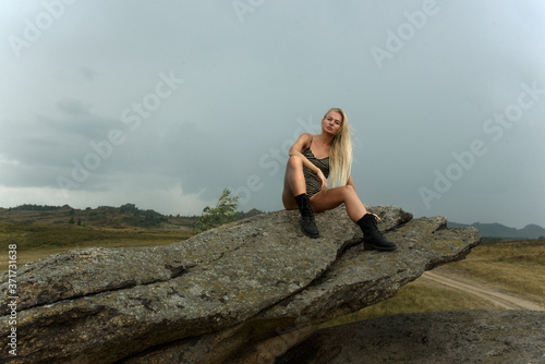 woman sits on a rock