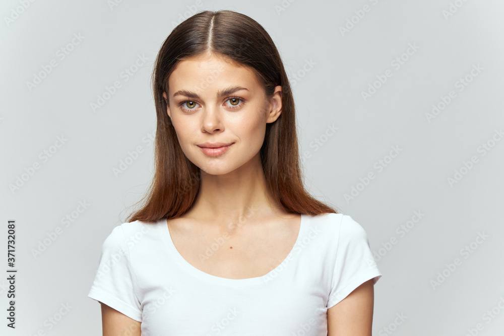 Beautiful brunette in a white T-shirt on an isolated background smile Copy Space Beautiful brunette in a white T-shirt on an isolated background smile Copy Space