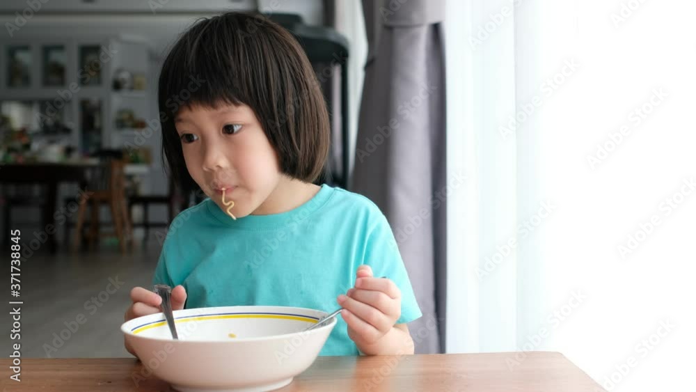 Asian kid eating noodles with blur background
Asian kid eating noodles with blur background