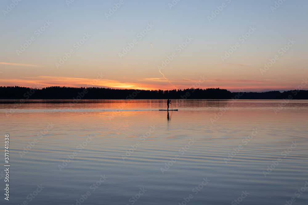 Paddleboarding at dusk and late summer sunset in Lappeenranta, Finland