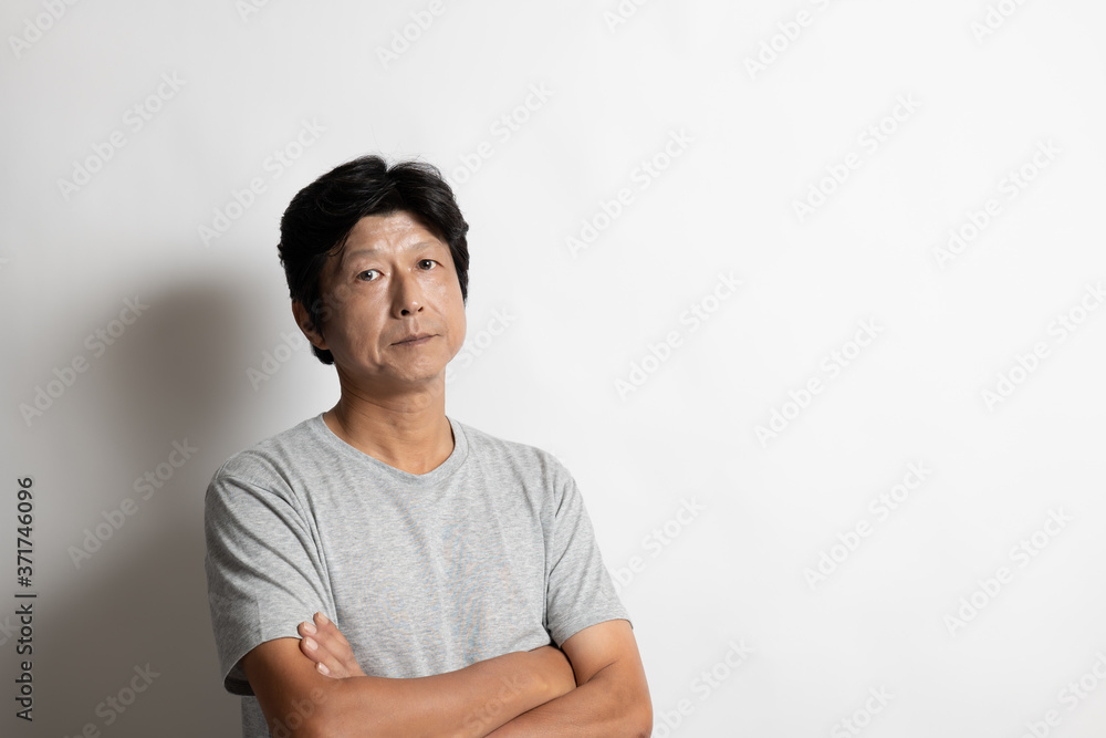 Fototapeta premium 腕を組むTシャツ姿の中年男性