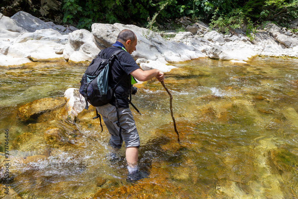 hiker standing in the water of a fiome in the gorges of the calore in Cilento hiker standing in the water of a fiome in the gorges of the calore in Cilento