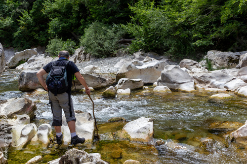 hiker standing in the water of a fiome in the gorges of the calore in Cilento