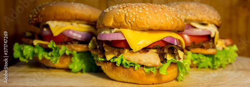 Fresh mouth-watering delicious burgers close-up on a yellow background.