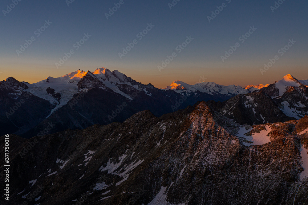 Die ersten Sonnenstrahlen am Gipfel der Berge im schönen Wallis in der Schweiz