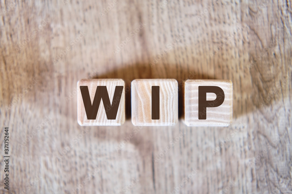 Fototapeta premium WIP - Abbreviation of work in progress on wood