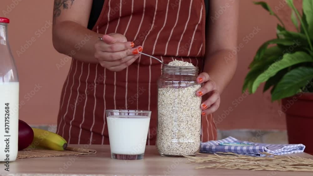 Mujer preparando el desayuno con leche y avena