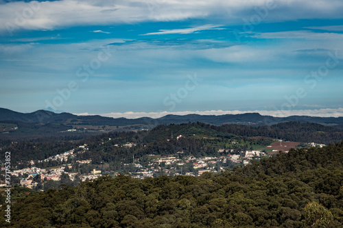 city view with mountain range and bright blue sky from hill top at day