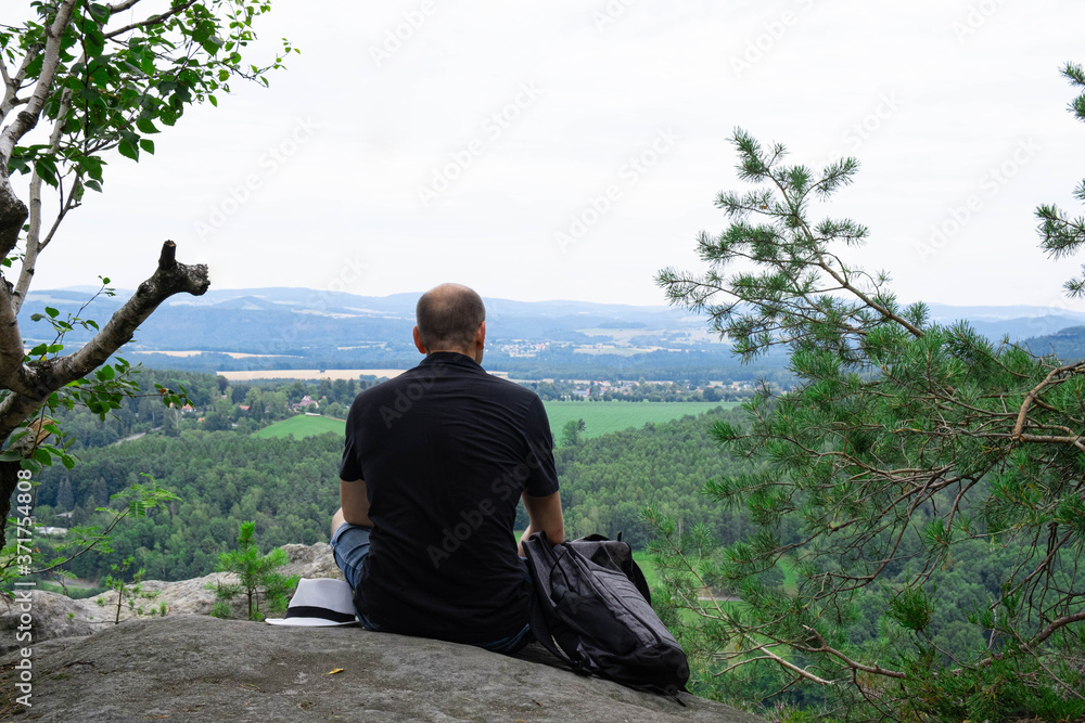 a traveler sitting at the edge of a mountain a traveler sitting at the edge of a mountain