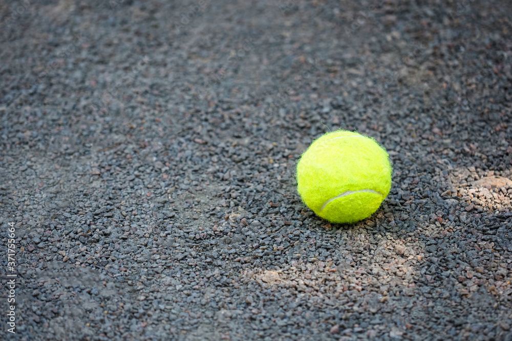 Green tennis ball on a tennis court, copy space