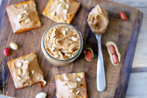 Selective focus. Peanut butter on crackers. Peanuts. A jar of peanut butter. High-calorie breakfast. Delicious snack.