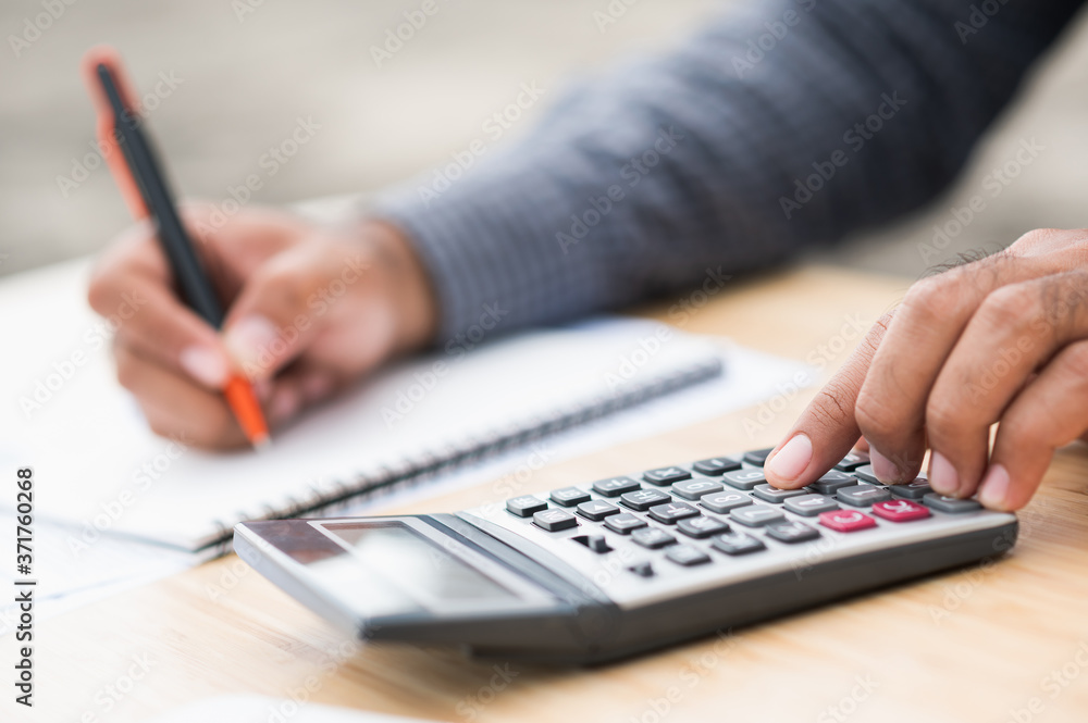 Close up businessman hand using calculator and note information financial administration. Close up businessman hand using calculator and note information financial administration.