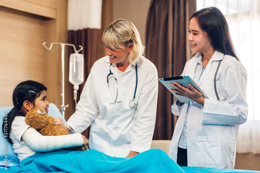 Smiling woman doctor service help support discussing and consulting talk to little girl patient give teddy bear and check up information in hospital Smiling woman doctor service help support discussing and consulting talk to little girl patient give teddy bear and check up information in hospital
