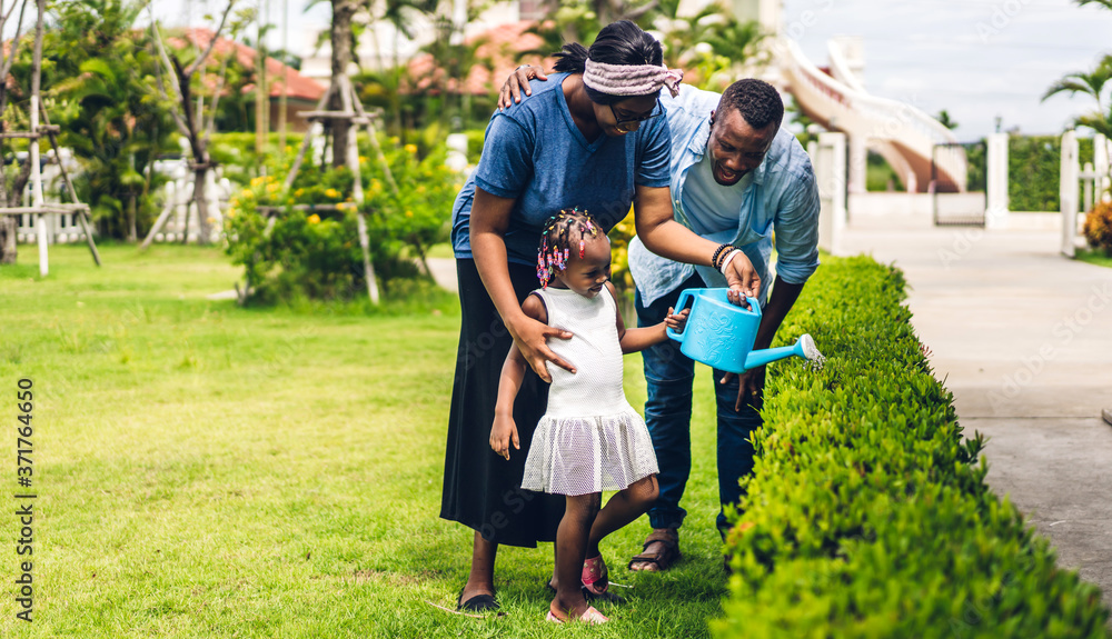 Fototapeta premium Portrait of enjoy happy love black family african american father and mother with little african girl child smiling and having fun moments good time in summer park at home