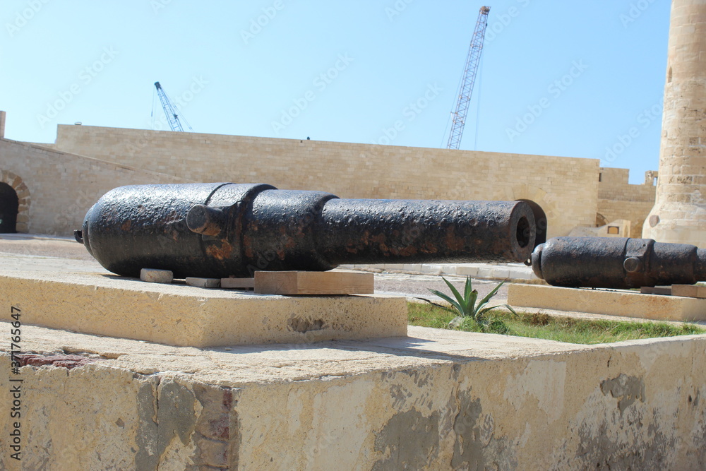 A cannon of the Citadel of Qaitbay in front of a defensive tower
