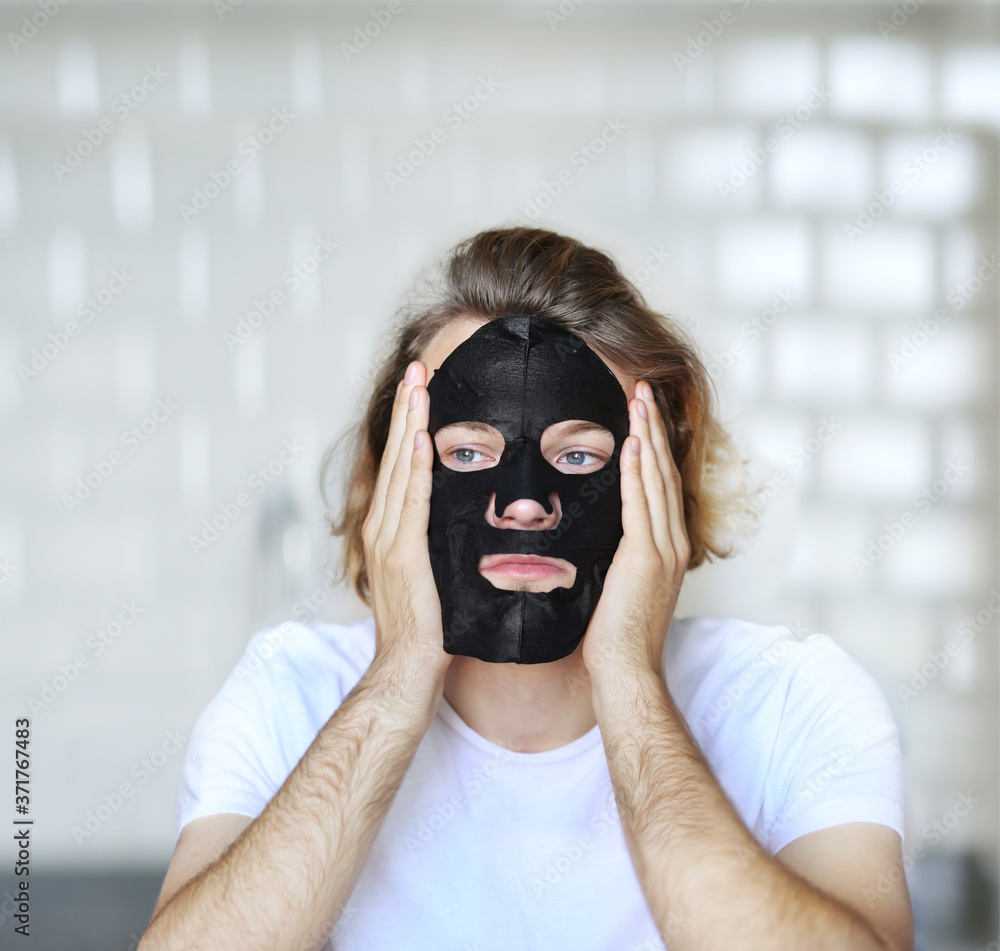 Anti-aging eye therapy. young man taking care of his undereye wrinkles applying facial mask. man moisturizing face mask. Cosmetology and skin care concept. Anti-aging eye therapy. young man taking care of his undereye wrinkles applying facial mask. man moisturizing face mask. Cosmetology and skin care concept.