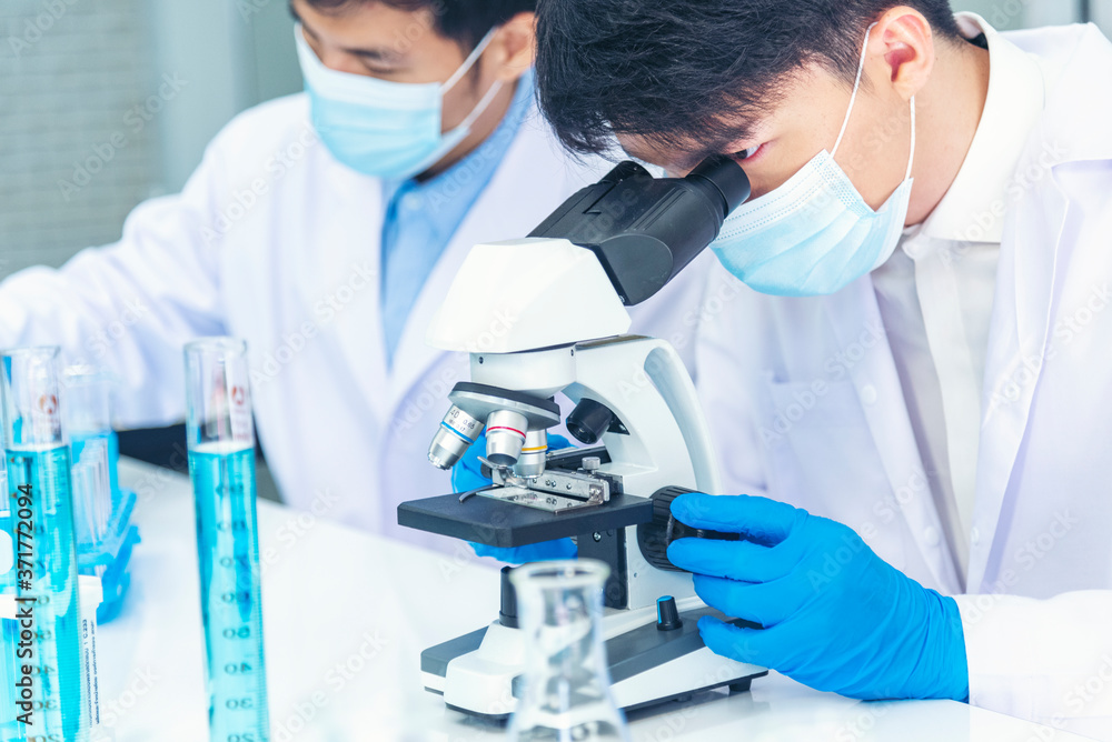 Fototapeta premium Two asian scientist team reserch chemistry science tube experiment biotech antibody sample in laboratory Cultivate Vaccine against covid-19 virus. Scientist consult, analyze in Chemistry Laboratory